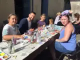 A family sit at a table painting
