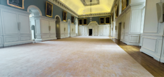 A hall with walls covered in portraits
