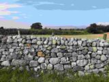 a stone wall with the mountains in the distance
