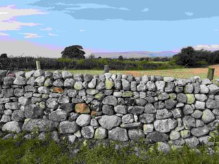 a stone wall with the mountains in the distance