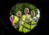3 children looking down a hole