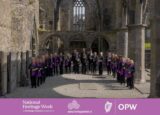 image of a choir standing in the grounds of an abbey
