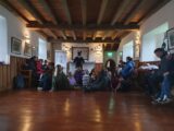 a man dressed as a skeleton is telling stories to children who are sitting down in front of him
