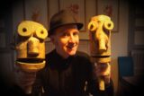 A man with two wooden animated characters